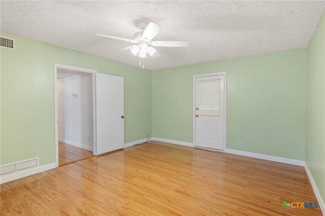 empty room featuring ceiling fan, a textured ceiling, and light wood-type flooring