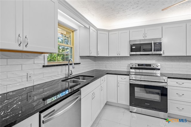 kitchen featuring a textured ceiling, white cabinetry, sink, and appliances with stainless steel finishes