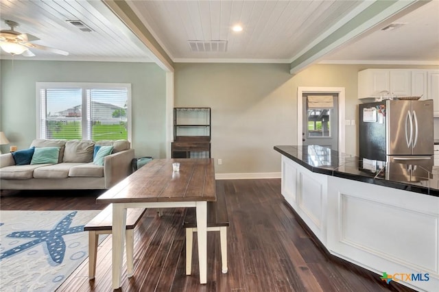11 Enchanted Ln, Port Lavaca, TX 77979 - kitchen with freestanding refrigerator, healthy amount of natural light, white cabinetry, crown molding, and dark wood finished floors