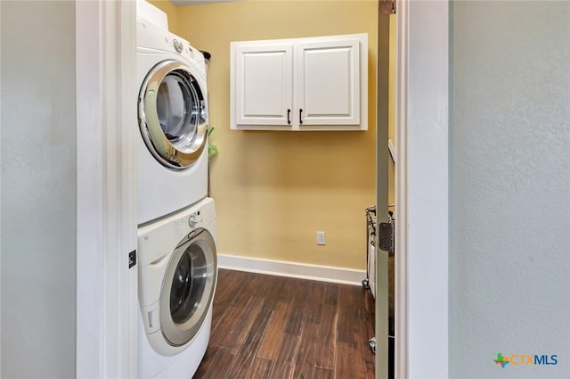 11 Enchanted Ln, Port Lavaca, TX 77979 - laundry area featuring stacked washer / dryer, dark wood-style flooring, and cabinet space