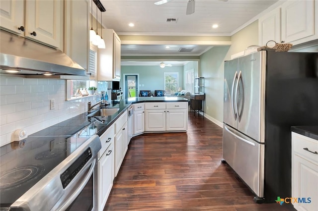 11 Enchanted Ln, Port Lavaca, TX 77979 - kitchen featuring stainless steel appliances, a ceiling fan, dark countertops, crown molding, and a peninsula