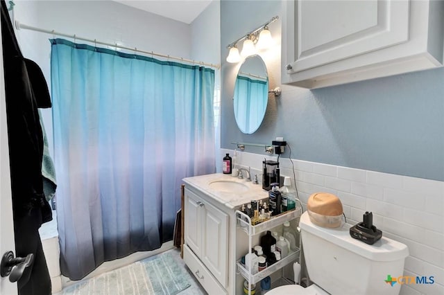 11 Enchanted Ln, Port Lavaca, TX 77979 - bathroom with vanity, tile walls, a shower with shower curtain, and wainscoting
