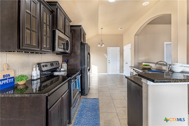 kitchen with stainless steel appliances, lofted ceiling, sink, tasteful backsplash, and light tile patterned flooring