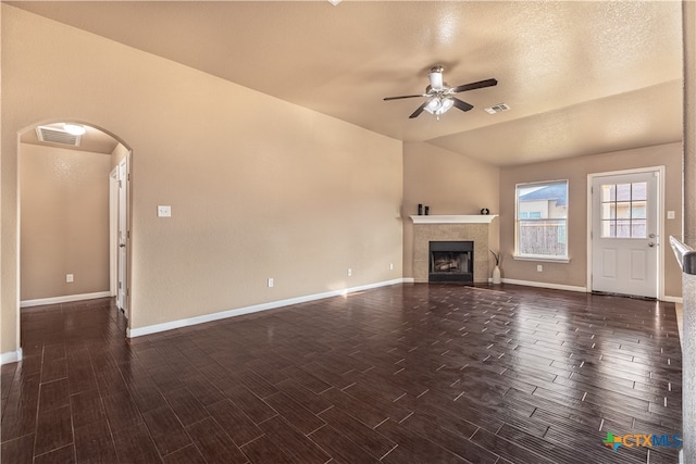 unfurnished living room with a textured ceiling, dark hardwood / wood-style flooring, lofted ceiling, and ceiling fan