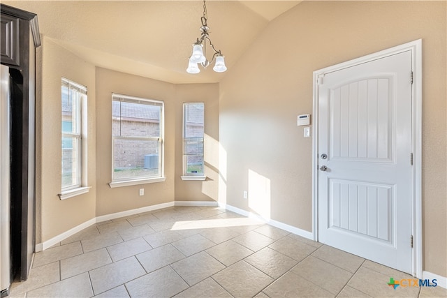 entrance foyer with a notable chandelier, light tile patterned floors, and lofted ceiling