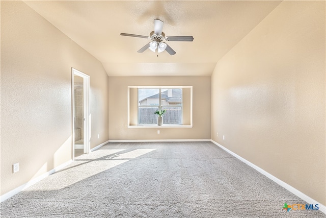 carpeted empty room with vaulted ceiling and ceiling fan