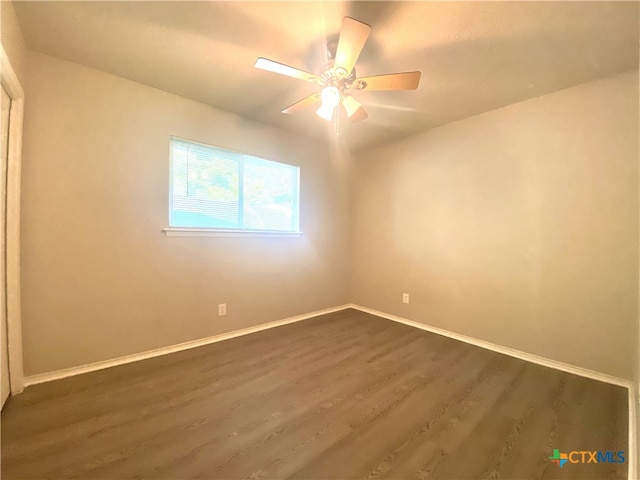 unfurnished room with dark hardwood / wood-style floors and ceiling fan