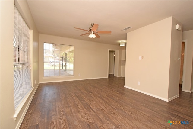 empty room with dark wood-type flooring and ceiling fan