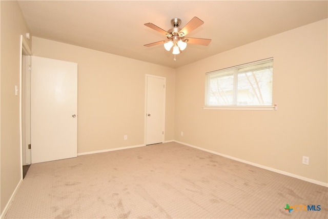 carpeted empty room featuring ceiling fan