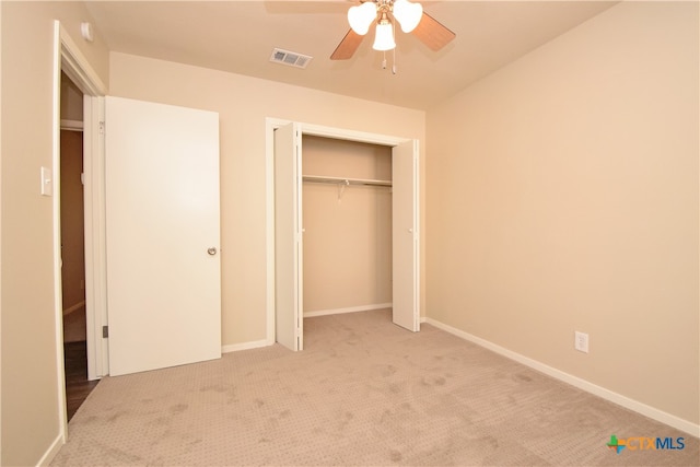 unfurnished bedroom with ceiling fan, a closet, and light colored carpet