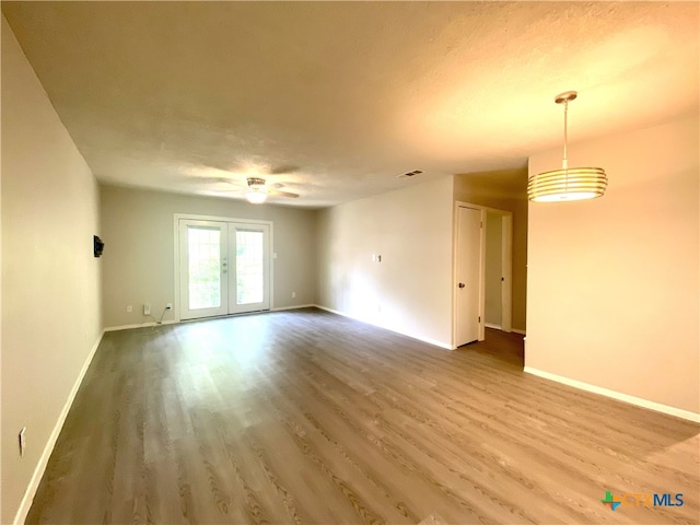 spare room with a textured ceiling, french doors, and hardwood / wood-style flooring