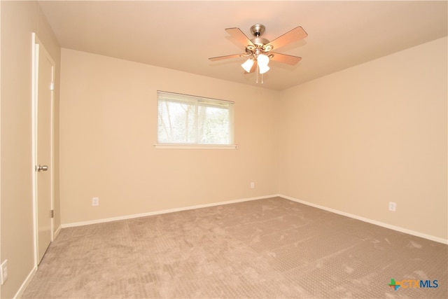 carpeted spare room with ceiling fan