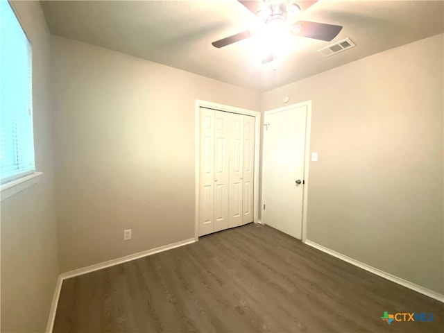 unfurnished bedroom with a closet, ceiling fan, and dark hardwood / wood-style floors