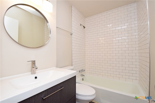 full bathroom featuring vanity, tiled shower / bath combo, and toilet