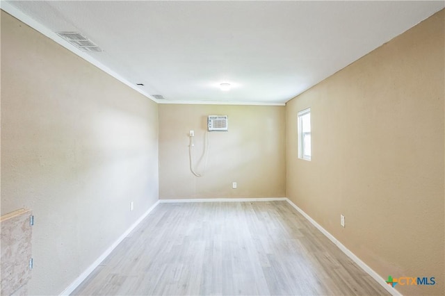 4803 Chad Dr, Killeen, TX 76542 - empty room featuring a wall mounted air conditioner, light wood-style flooring, baseboards, visible vents, and ornamental molding
