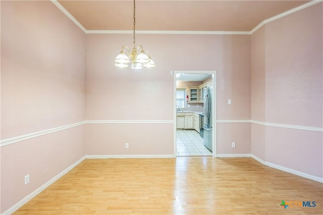 4803 Chad Dr, Killeen, TX 76542 - spare room with an inviting chandelier, baseboards, and light wood-style flooring