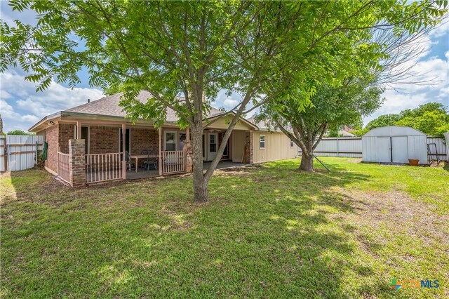 4803 Chad Dr, Killeen, TX 76542 - back of property featuring a fenced backyard, a shed, brick siding, a lawn, and an outbuilding