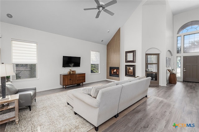 living room featuring ceiling fan, a fireplace, high vaulted ceiling, and hardwood / wood-style floors