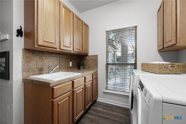 clothes washing area featuring washer and dryer, sink, cabinets, and plenty of natural light