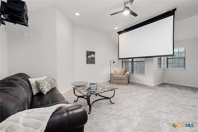 home theater room with light colored carpet, vaulted ceiling, and ceiling fan