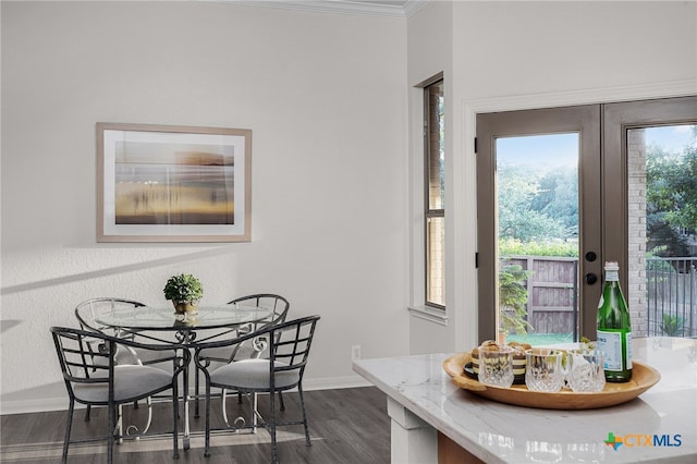 dining space with dark hardwood / wood-style floors, crown molding, and french doors