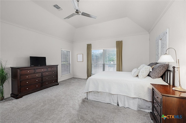 bedroom with ceiling fan, crown molding, lofted ceiling, a tray ceiling, and light carpet