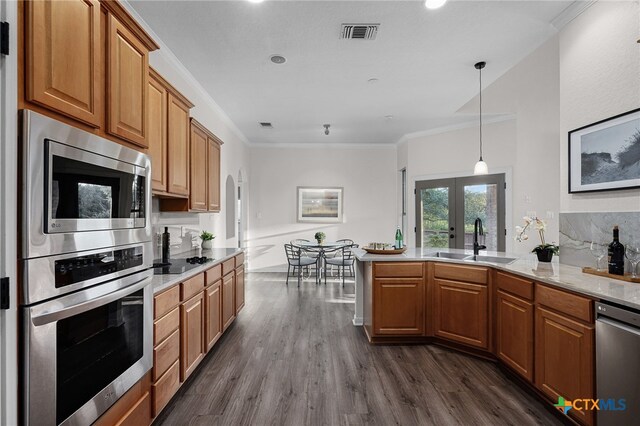 kitchen with sink, hanging light fixtures, multiple ovens, dark hardwood / wood-style flooring, and ornamental molding