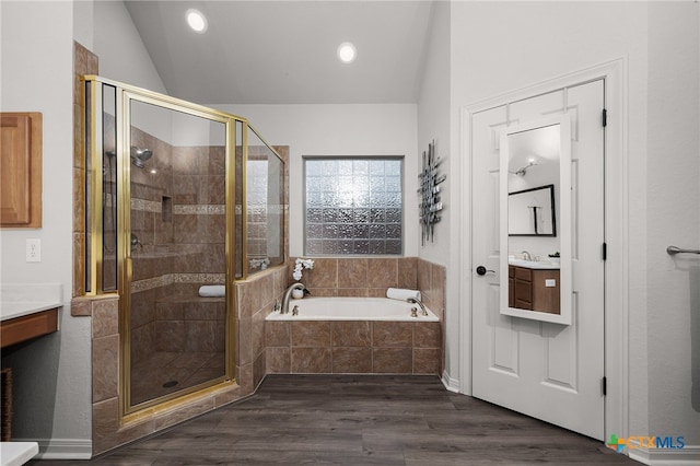 bathroom with plus walk in shower, hardwood / wood-style floors, and vanity