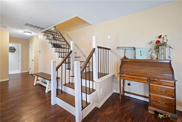 staircase with baseboards, visible vents, and wood finished floors