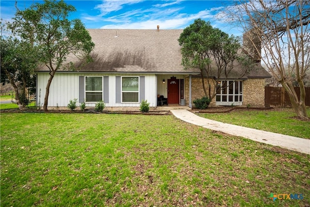 view of front of house with a front lawn and roof with shingles