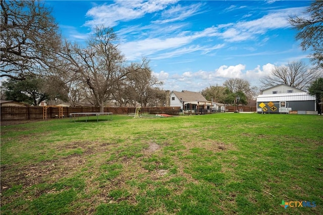 view of yard with a fenced backyard and a trampoline