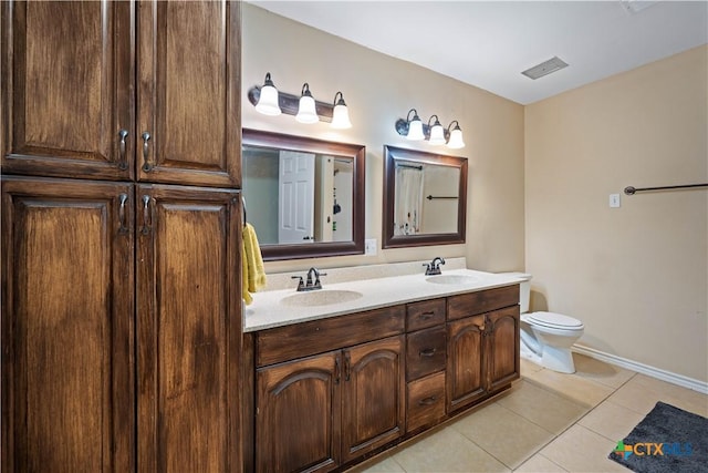 bathroom featuring double vanity, a sink, toilet, and tile patterned floors