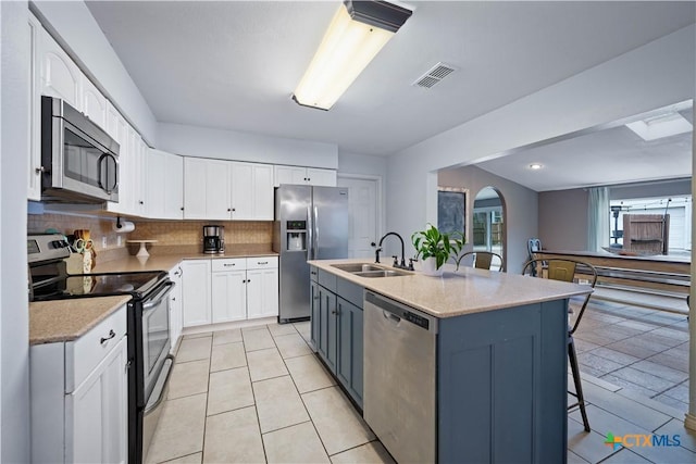 kitchen with a center island with sink, visible vents, appliances with stainless steel finishes, white cabinets, and a sink