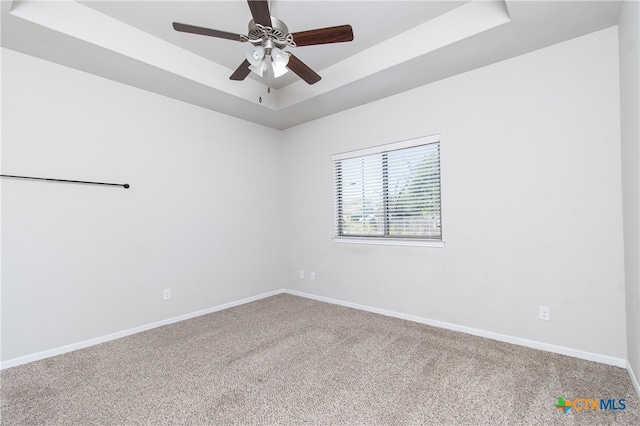 unfurnished room with carpet flooring, ceiling fan, and a raised ceiling