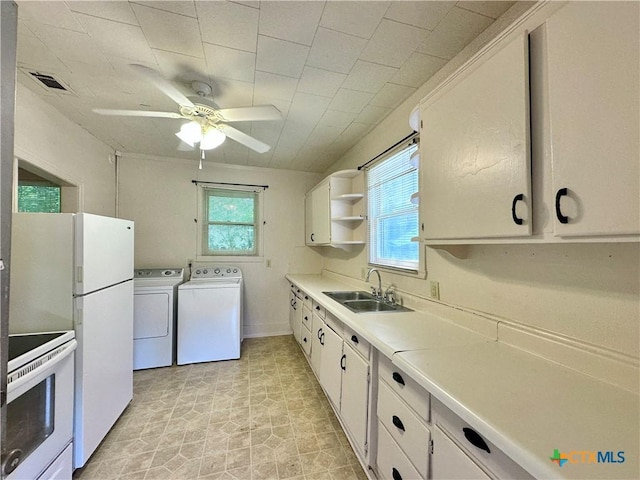 1015 N 3rd St, Temple, TX 76501 - kitchen featuring white appliances, separate washer and dryer, and white cabinets