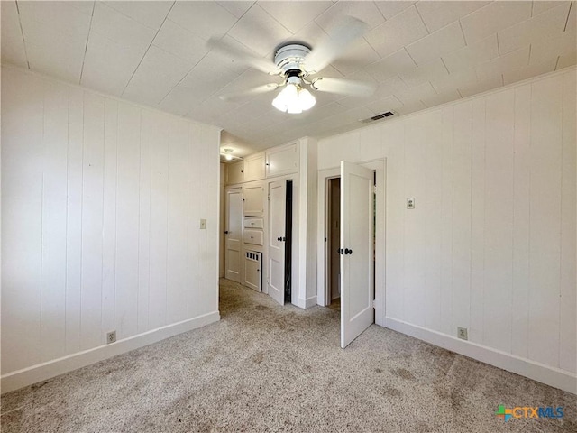 1015 N 3rd St, Temple, TX 76501 - unfurnished bedroom with light carpet, wooden walls, and a ceiling fan