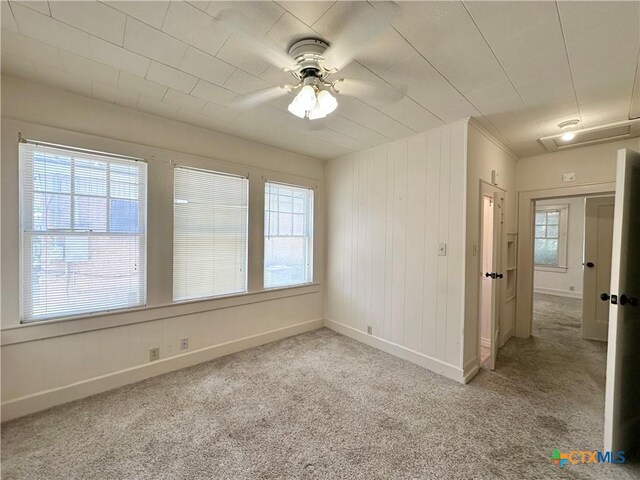 1015 N 3rd St, Temple, TX 76501 - carpeted spare room with plenty of natural light, a ceiling fan, and wooden walls