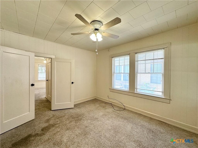 1015 N 3rd St, Temple, TX 76501 - carpeted empty room with a ceiling fan and wood walls