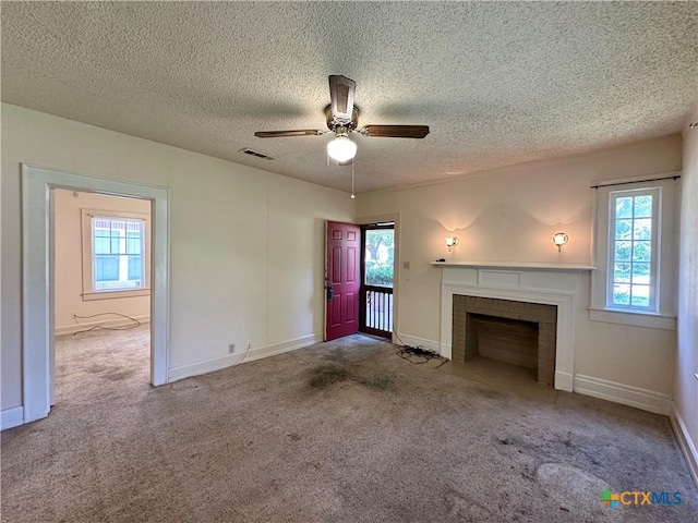 1015 N 3rd St, Temple, TX 76501 - unfurnished living room with a fireplace, a ceiling fan, carpet flooring, and a textured ceiling