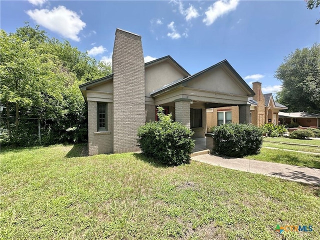 1015 N 3rd St, Temple, TX 76501 - view of front of home with a chimney, brick siding, and a front yard