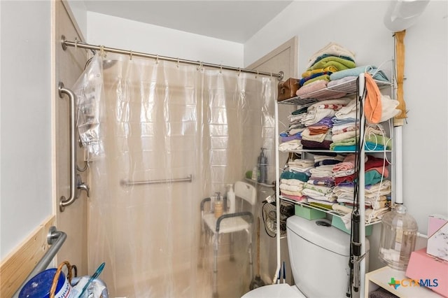 bathroom featuring toilet and a shower with shower curtain