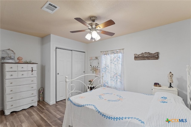 bedroom featuring ceiling fan, a textured ceiling, a closet, and light wood-type flooring