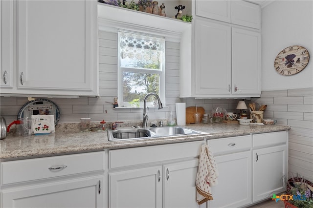 kitchen featuring white cabinets, sink, and decorative backsplash