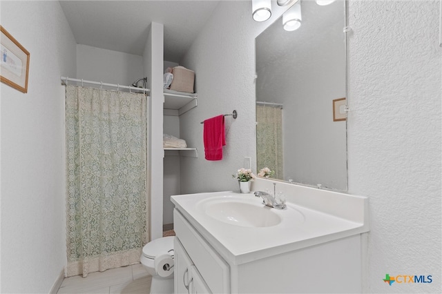 bathroom featuring walk in shower, vanity, and toilet