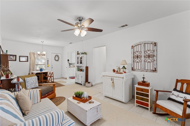 living room with ceiling fan with notable chandelier and light tile patterned floors