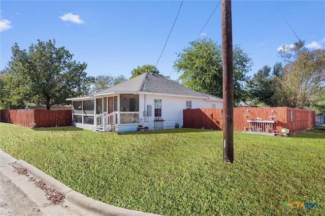 view of property exterior with a sunroom and a yard