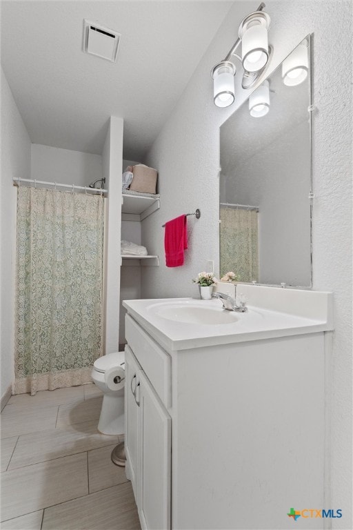 bathroom with tile patterned flooring, vanity, and toilet