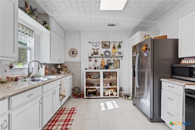 kitchen featuring stainless steel appliances, sink, light stone counters, backsplash, and white cabinets