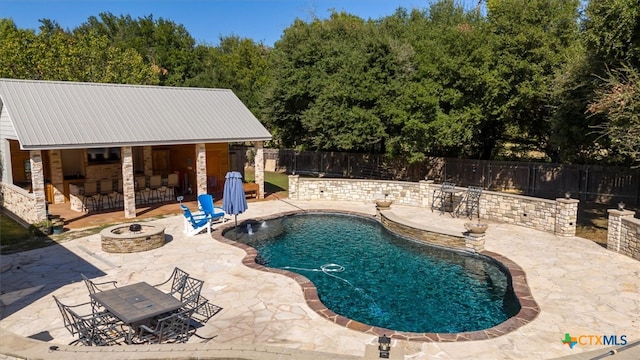 view of swimming pool with a patio and a fire pit