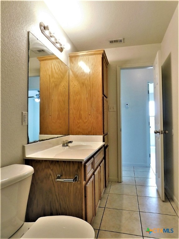 bathroom with vanity, tile patterned flooring, and toilet